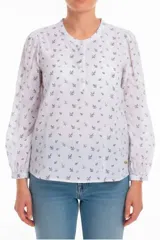 Blusa blanca de manga larga con estampado de hojas pequeñas en gris. Tiene cuello redondo, cierre frontal con botones personalizados y mangas abullonadas con puños elásticos.