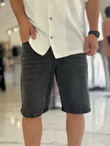 Bermuda de jean de corte oversize, en color negro con efecto gastado.