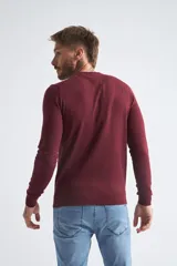 Sweater de algodón en butoné color verde, con cuello redondo, puños y dobladillo acanalados, y logo bordado en el pecho.