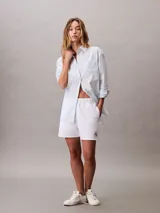 Shorts de talle alto confeccionados en mezcla de algodón y poliéster, con cintura elástica, bolsillos laterales y logo monograma de Calvin Klein bordado en el bajo.