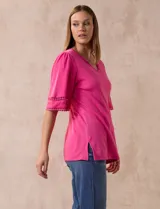 Remera de algodón color fucsia, marca Ruby Rd. con cuello redondo con escote en V y mangas cortas amplias con aplique de crochet en el borde.