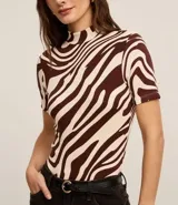 Blusa de rib color crema con estampado de cebra en marrón. Tiene cuello alto y mangas cortas.