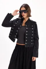 Chaqueta de jean estilo napoleónico color negro, con cuello mao, hombreras y filas dobles de botones metálicos grabados.