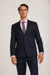 Ambo de vestir para hombre compuesto por saco de dos botones y pantalón de corte recto, en color azul marino. El saco presenta solapas clásicas y bolsillos con solapa, mientras que el pantalón cuenta con un ajuste entallado.
