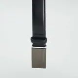 Cinturón de cuero sintético negro con hebilla automática plateada con diseño texturizado.