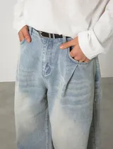 Jean baggy de tiro alto y lavado claro, con diseño amplio, pinzas y efecto desgastado en los muslos.