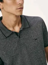 Polo de hombre color gris oscuro jaspeado, con cuello y puños de manga con ribete negro. Presenta un pequeño logo bordado en el pecho.