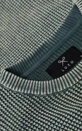 Sweater de cuello redondo con diseño de tejido texturizado en color verde y blanco. Presenta un calce relajado y terminaciones en punto rib en el cuello.