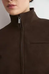 Chaqueta de cuero color marrón oscuro, con cuello alto, cierre frontal y diseño minimalista de corte recto.