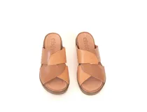 Sandalias de cuero color caramelo, con tiras cruzadas en el empeine, plataforma baja y suela de poliuretano flexible.