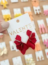 Aros colgantes marca Valente Accesorios, color rojo, con diseño de pétalos texturizados.
