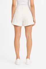 Short de jean blanco de tiro alto, con bolsillos frontales grandes de parche, presillas para cinto y botamanga con dobladillo.