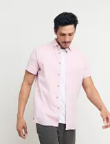 Camisa azul de manga corta, con cuello abotonado y bolsillo en el pecho.