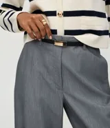 Pantalón de sastrería corte recto confeccionado en crepé, con trabillas en la cintura, bolsillos traseros y cinto fino incluido.