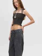 Top crop de tela fruncida con diseño ajustado al cuerpo, breteles finos con lazos ajustables y ruedo con volado.