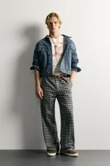 Pantalón flare fit confeccionado en tejido con algodón, con estampado a cuadros en tonos grises y negros. Cuenta con bolsillos laterales, bolsillos traseros de vivo y cierre frontal con cremallera y botón.