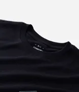 Remera masculina de manga corta, color negro, con cuello redondo. Presenta un estampado pequeño en el pecho con un diseño geométrico y un estampado grande en la espalda con un paisaje natural y la frase "Inspired & Discover".