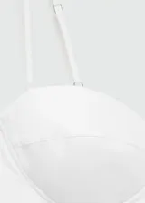 Vestido corto de color blanco con escote corazón y tirantes finos ajustables. Presenta un diseño tipo corset en la parte superior y una falda con volumen tipo globo. Incluye cierre lateral invisible.