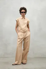 Camisa azul marino con cierre frontal de botones y dobladillo ajustable con cordones de tela.