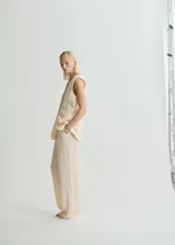 Pantalón de tiro alto con diseño recto y largo. Cuenta con detalle de pinzas, bolsillos laterales y bolsillos de ribete en la parte posterior. Incluye cierre oculto de botón, gancho y cremallera, además de trabillas para cinturón y forro interior.