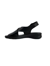 Sandalia de cuero negro con diseño de tiras cruzadas en el empeine, una de ellas con textura grabada. Cuenta con cierre de hebilla lateral y suela plana ergonómica.