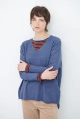 Sweater de punto en color azul, con escote en V, mangas largas y corte holgado con ruedo asimétrico.