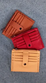 Tarjetero color verde agua con presilla frontal y múltiples ranuras para tarjetas. Incluye un bolsillo con cierre para monedas o billetes.