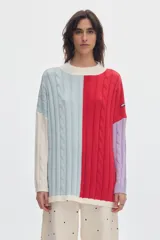 Buzo de punto oversized con diseño colorblock en celeste, rojo, blanco y lila. Presenta cuello redondo, tejido de ochos, pequeños tajos laterales y parche de la marca en la manga.