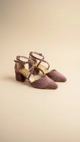 Zapato de tacón ancho de 5 cm, confeccionado en tela de tapicería color malva, con diseño de punta fina, escote en V y tiras cruzadas en diagonal con cierre de hebilla ajustable.