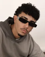 Lentes de sol negros con marco rectangular y lentes oscuros, estilo retro. Ofrecen protección UV400 y son polarizados.