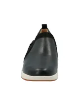 Zapatilla tipo slip-on Hush Puppies modelo Spinal, confeccionada en cuero negro con detalles en gamuza y cierre lateral. Cuenta con una suela de goma blanca con base antideslizante y tecnología de amortiguación.