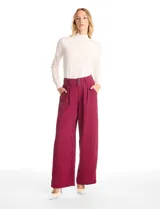 Pantalón de corte palazzo con pierna ancha y caída fluida. Presenta tiro alto con doble abotonadura frontal, pinzas estratégicas en la cintura y bolsillos laterales funcionales. Incluye cintura elástica en la parte posterior para mayor ajuste.