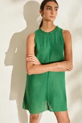 Vestido corto de lino italiano, sin mangas y con cuello redondo a la base. Presenta detalles desflecados en el cuello y costura central vertical.