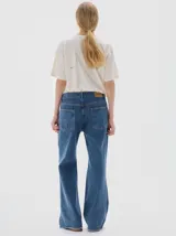 Jean de corte flare con tiro medio, confeccionado en denim de algodón con lavado vintage y desgaste en costuras. Presenta costuras en hilo color oro.