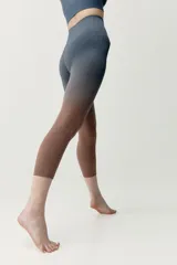 Calza deportiva corta de diseño seamless, con efecto degradado que transiciona del gris azulado en la parte superior al marrón en las piernas.
