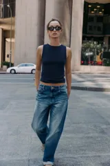 Top de punto color amarillo mostaza, con cuello redondo y manga sisa. Acabados en rib a tono.