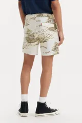 Bermuda de corte clásico con estampado tropical de palmeras y paisajes en tonos tierra sobre fondo beige. Cuenta con cierre de botón y cremallera, bolsillos laterales y bolsillos traseros.