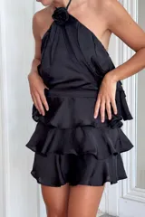 Pollera corta de tres volados con pretina elástica en la parte trasera, confeccionada en tela satinada.