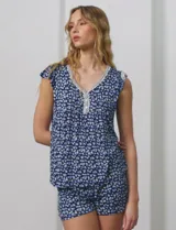 Conjunto de pijama de short y remera en tejido soft estampado. Remera de escote en V con aplique de puntilla, botones y detalle plisado. Short con cintura elastizada.