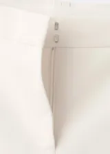 Pantalón sastrero de tiro bajo y diseño largo con botamanga acampanada, color blanco, con trabillas y cierre oculto.