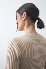 Sweater de tejido tipo rib, color negro, con cuello redondo y mangas largas. Presenta una textura acanalada y un ajuste al cuerpo.