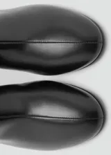 Botin de cuero vacuno color negro, con taco bloque de 5,5 cm, punta redonda y cierre de cremallera en la parte posterior.