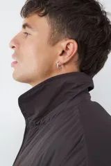 Campera acolchada de color gris oscuro, con diseño de cuello tipo camisa, cierre frontal con cremallera y bolsillos laterales. Presenta puños y ruedo con elástico.