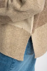 Sweater de punto con diseño de bloques de color en tonos beige y marrón, de corte oversize, cuello redondo y mangas largas con puños acanalados.