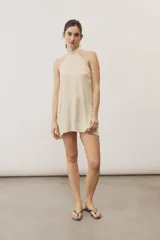 Top halter celeste con diseño asimétrico de corte más largo en la parte trasera, cuello alto y sutil estampado floral.