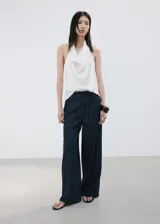 Pantalón de mezclilla azul oscuro, con silueta wide leg, tiro alto y pretina con cordón ajustable.