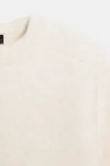 Jersey de punto de cuello redondo y manga larga con hombreras, de corte clásico y color crudo.