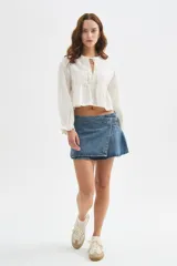 Minifalda de denim con diseño cruzado, efecto tableado y detalle de hebilla lateral.