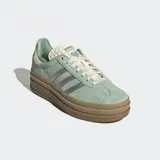 Championes Adidas Gazelle Bold color verde agua con detalles plateados y suela de plataforma marrón. Confeccionados en gamuza, cuero y material sintético.