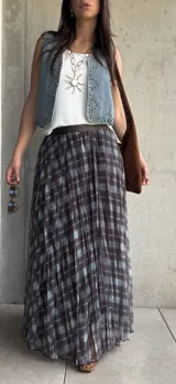 Pollera larga plisada con estampado a cuadros en tonos marrón y celeste, con pretina elástica.